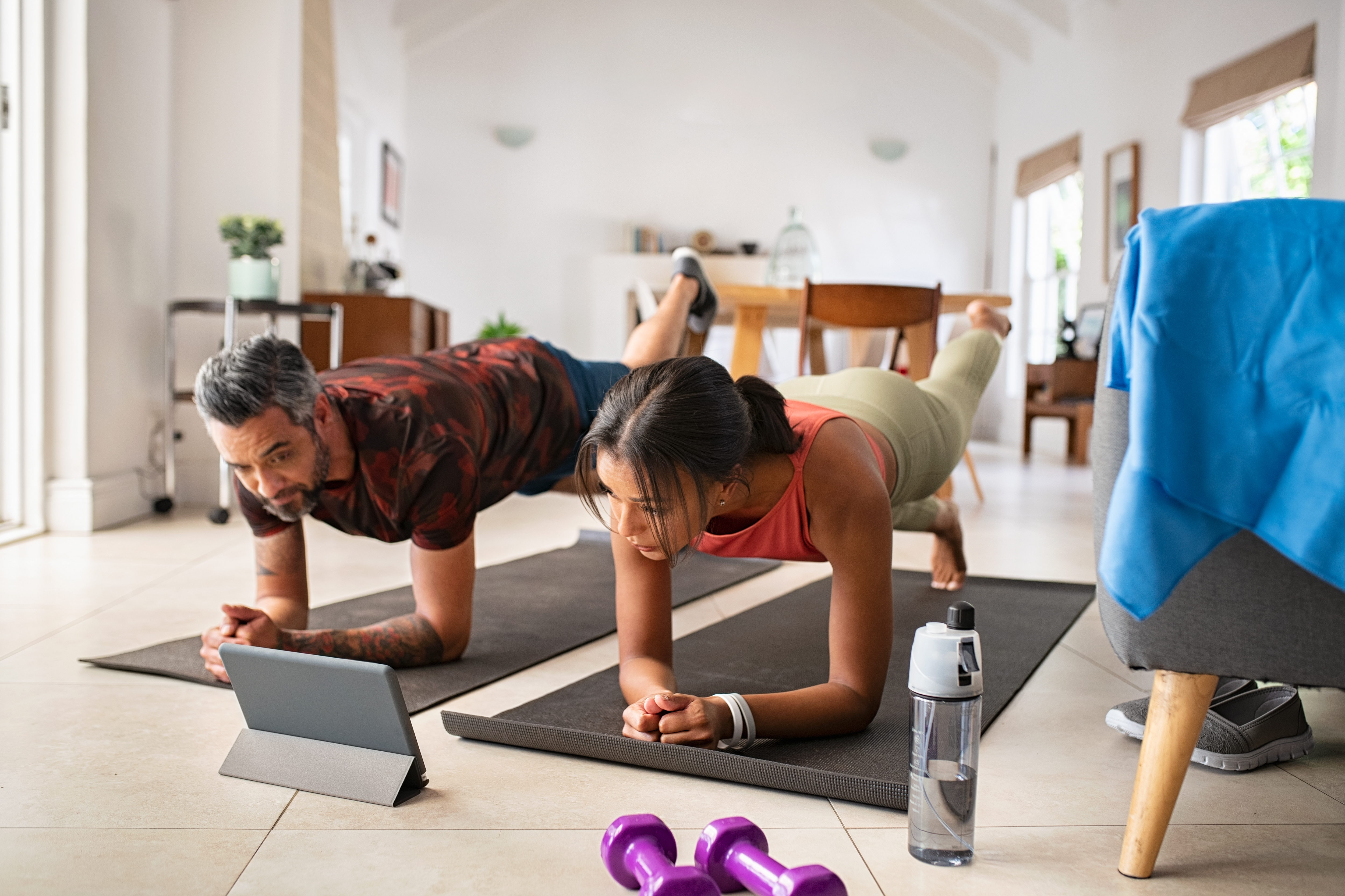 A couple practicing stretching exercises at home